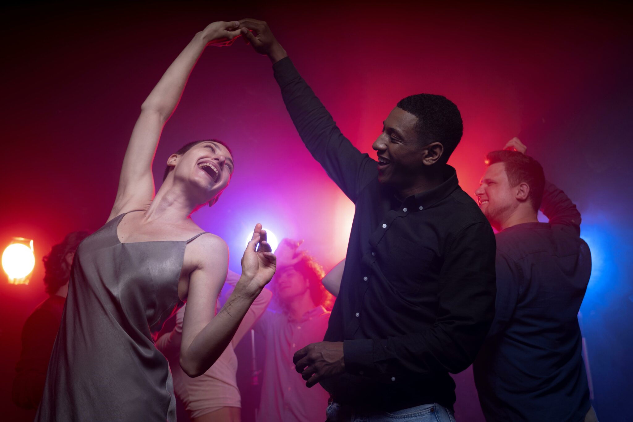 Danseurs souriants pendant une soirée festive liée aux cours de danse à Cazes-Mondenard, ambiance joyeuse et colorée.